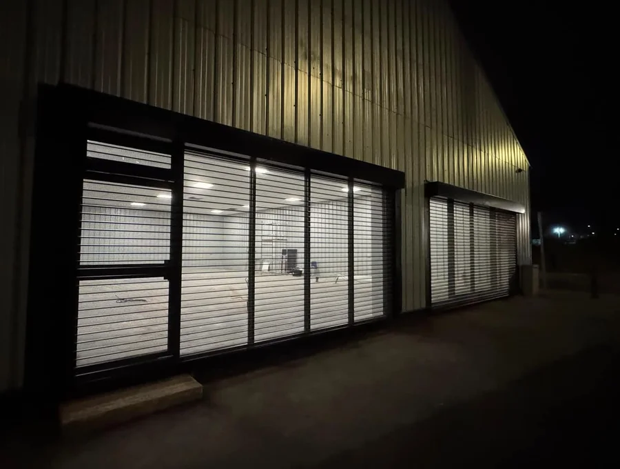 Commercial shopfront secured with roller shutters at night