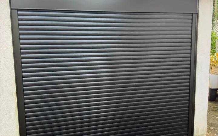 New black insulated roller garage door fitted to a home