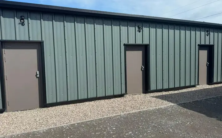 Steel personnel doors fitted to a green-clad industrial unit