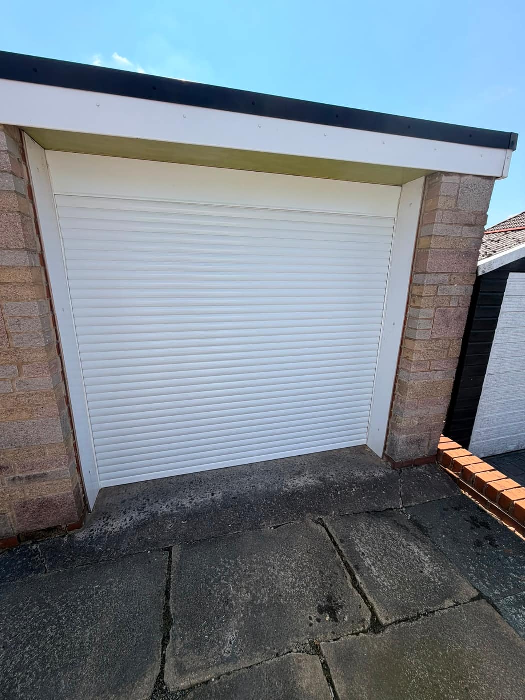 White insulated roller garage door fitted to a Bolton home