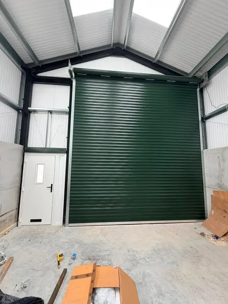 Green industrial roller shutter inside a steel workshop unit