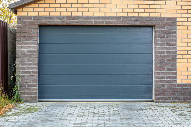 Anthracite sectional garage door on a brick garage